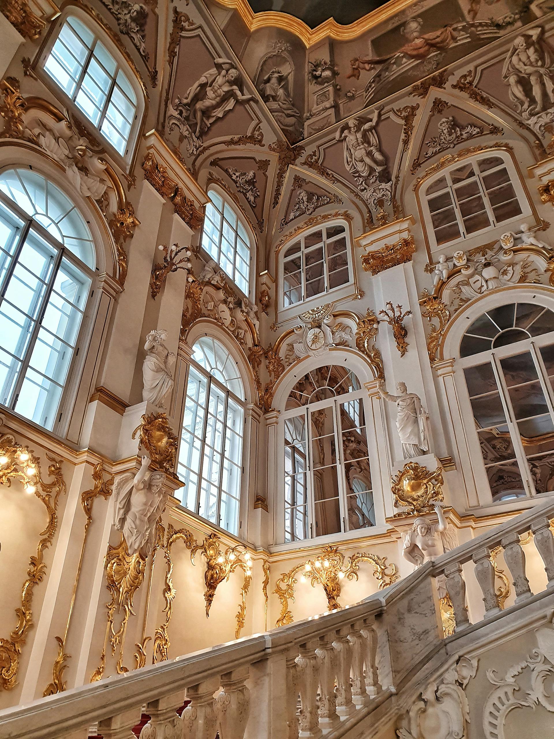 Luxurious Baroque interior with gilded details in Russia's Winter Palace, showcasing ornate design.